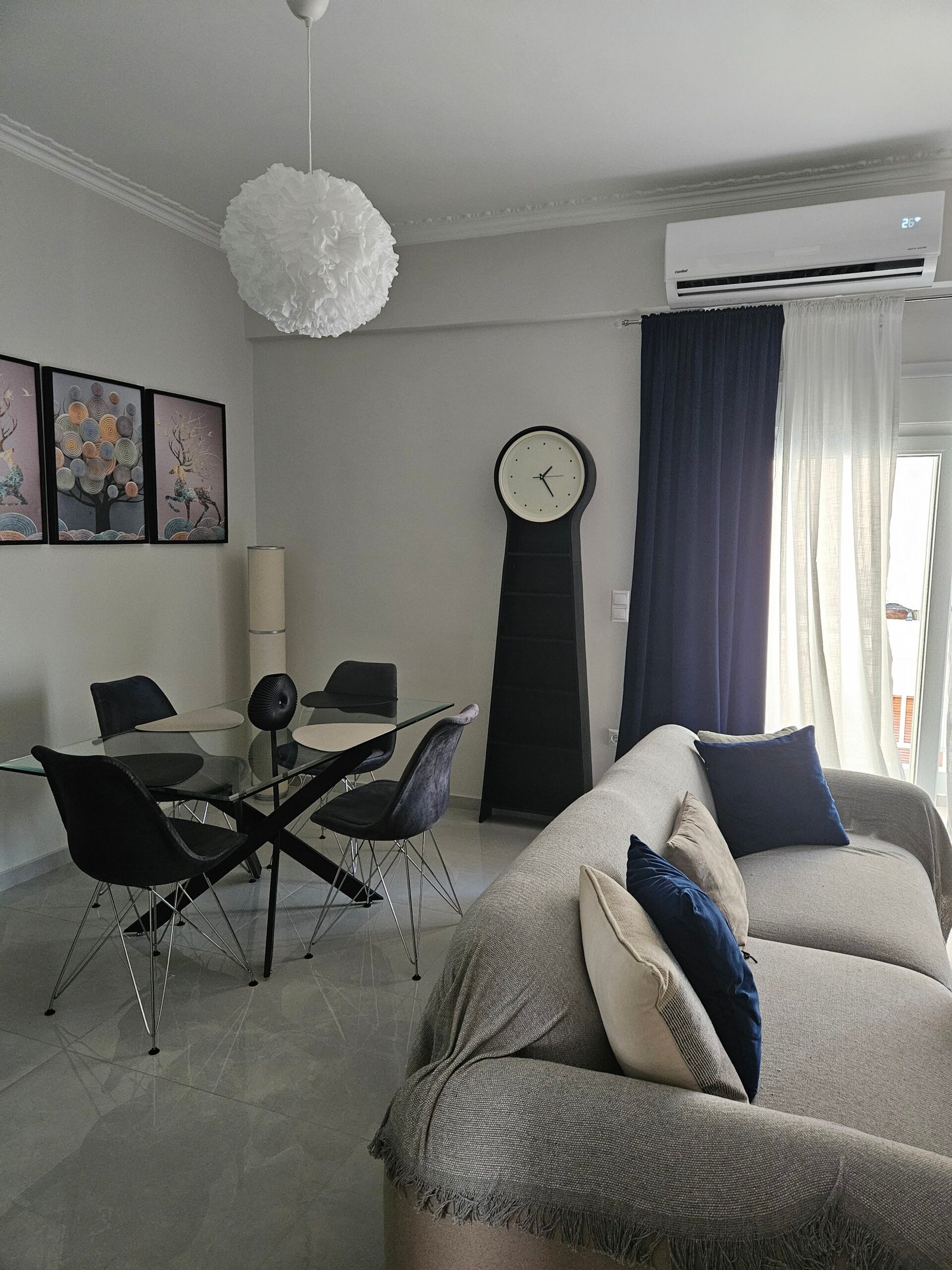 Open-plan living and dining area with air conditioning and balcony access