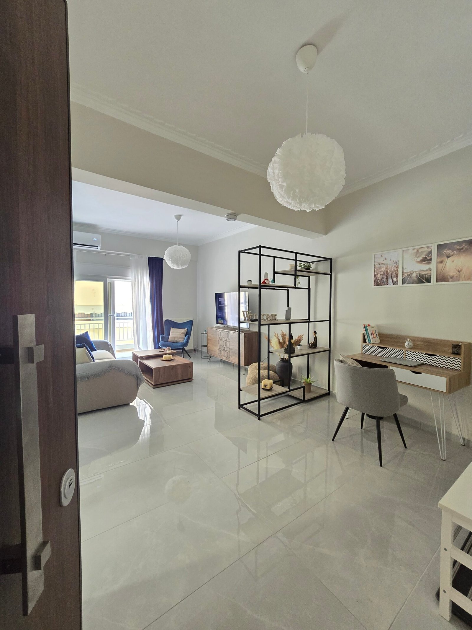 Open-plan living area with dedicated workspace and balcony access