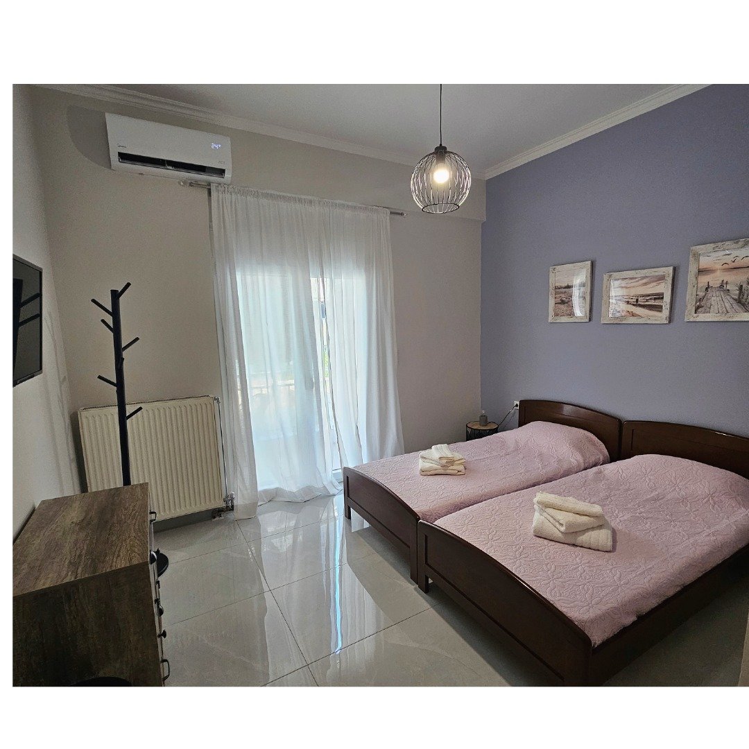 Bright second bedroom with two single beds and balcony access