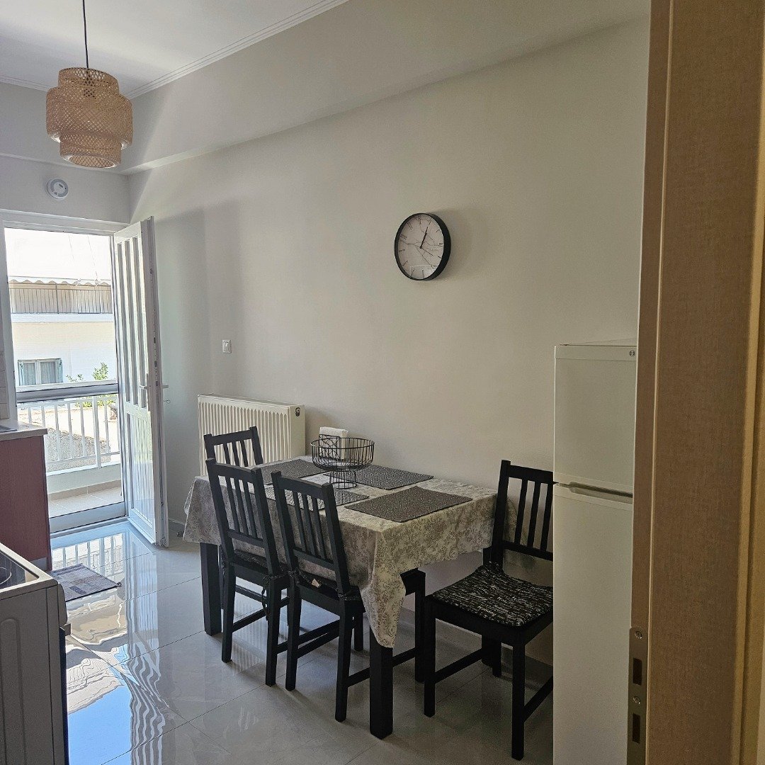 Kitchen dining area with table for four and full-size refrigerator