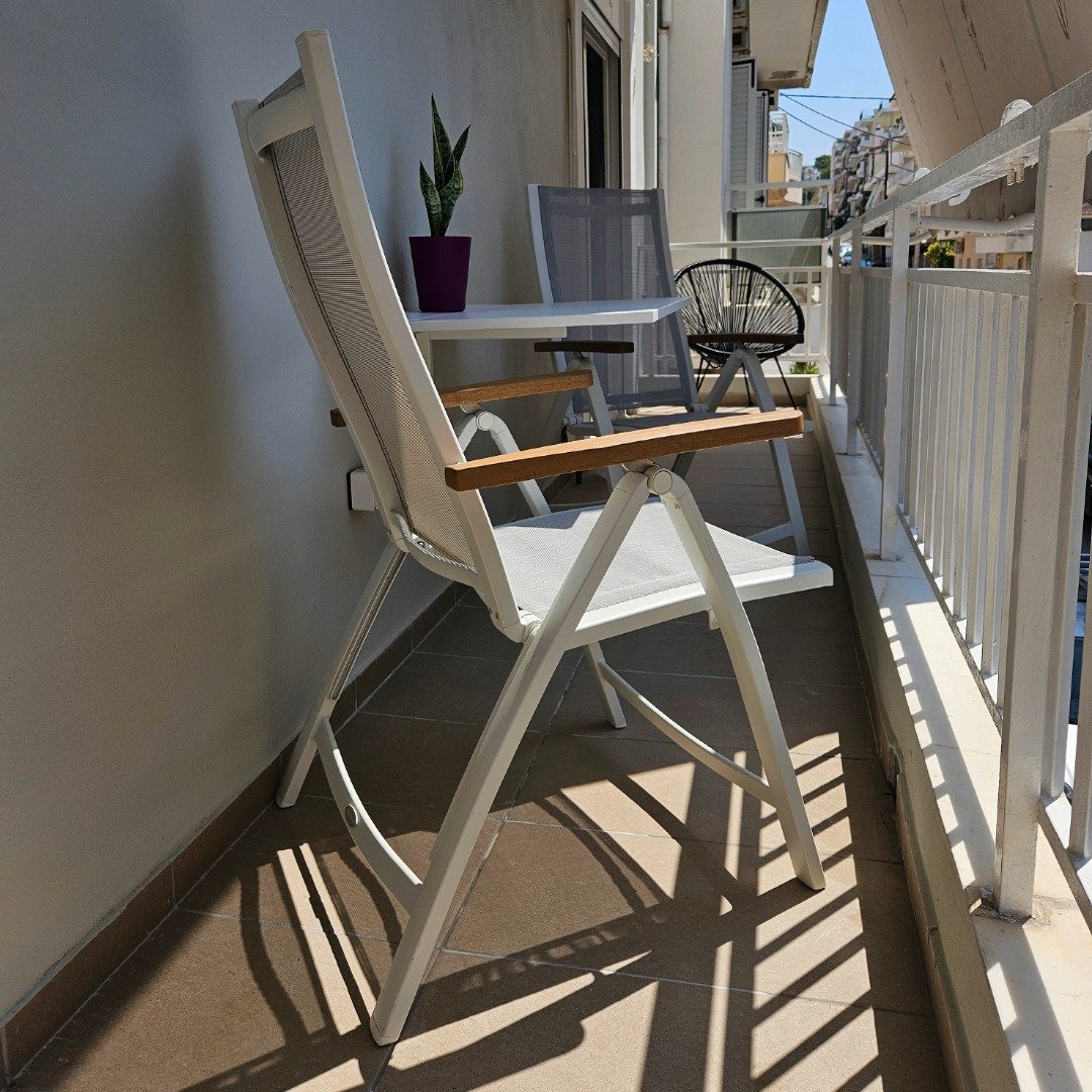 Long private balcony with reclining chairs and outdoor table